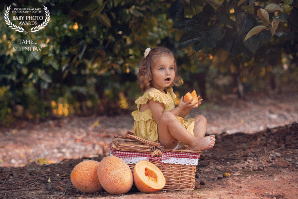 Melon. It's summertime, and we have so much fun! This is the season when you can enjoy the sweetest fruit there is! In this picture, this beautiful little girl, who's answering the name Emily, at her own private picnic, tastes a cold and sweet melon. Fun to enjoy the moment, even more fun than this moment is capture forever.